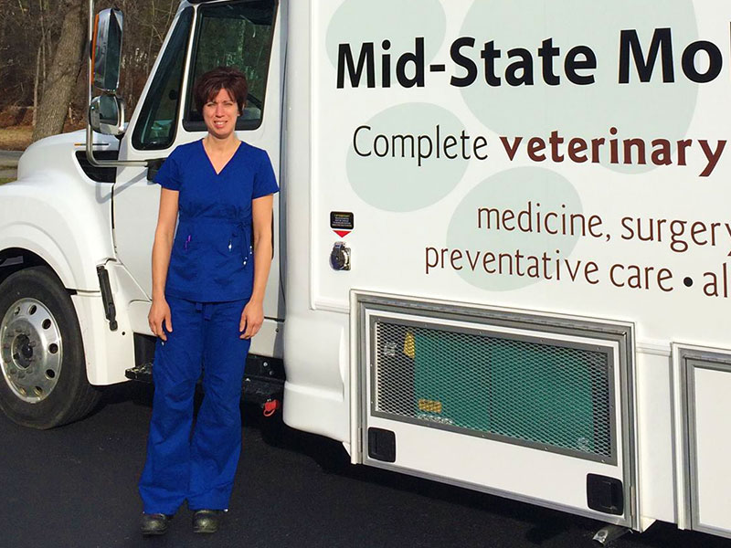 Michelle Bianco, D.V.M. syanding in front of Mi-State Mobile Veterinary Clinic's Van